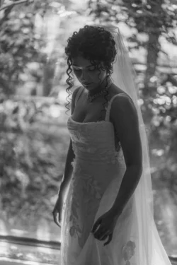 Hair styling for wedding - a black and white photo of the bride with dark curly hair, in an updo.