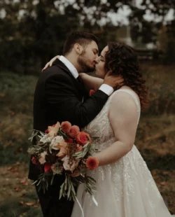 hair styling for wedding - a bride and groom kissing. The bride has curly dark hair.