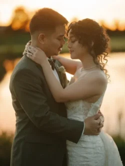 hair styling for wedding - updo with curly hair, bride and groom standing arm in arm.